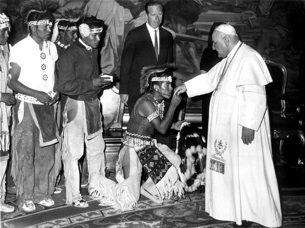 Индеец племени апачи преклоняет колени и целует руку Папы Иоанна XXIII во время аудиенции делегации индейцев